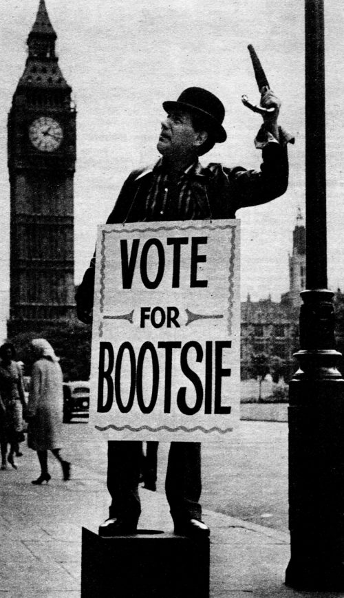 A man in a sandwich board reading "VOTE FOR BOOTSIE"