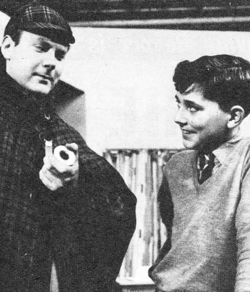A boy looks at a man holding his pipe